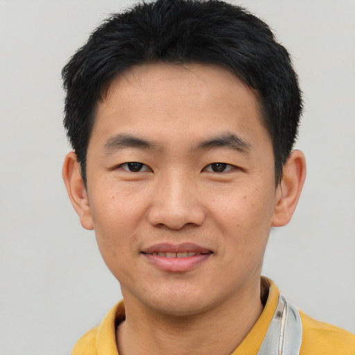 Joyful asian young-adult male with short  brown hair and brown eyes