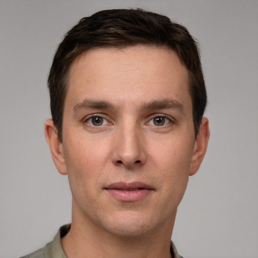 Joyful white young-adult male with short  brown hair and grey eyes