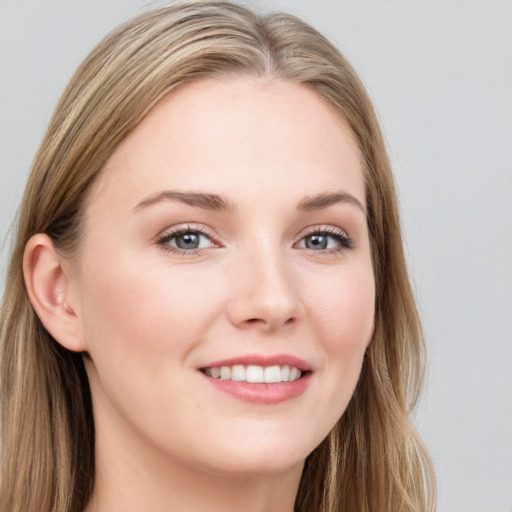 Joyful white young-adult female with long  brown hair and blue eyes