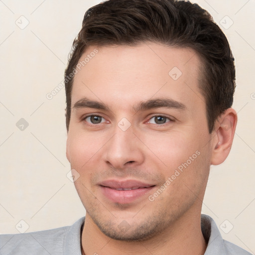 Joyful white young-adult male with short  brown hair and brown eyes