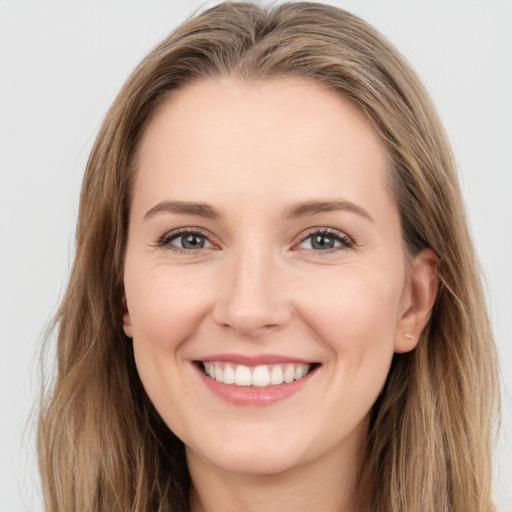 Joyful white young-adult female with long  brown hair and brown eyes