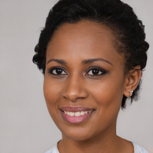 Joyful black young-adult female with short  brown hair and brown eyes