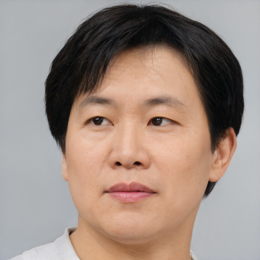 Joyful asian adult male with short  brown hair and brown eyes
