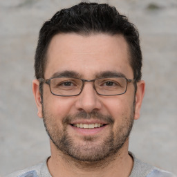 Joyful white young-adult male with short  black hair and brown eyes