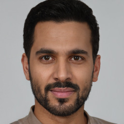 Joyful latino young-adult male with short  black hair and brown eyes