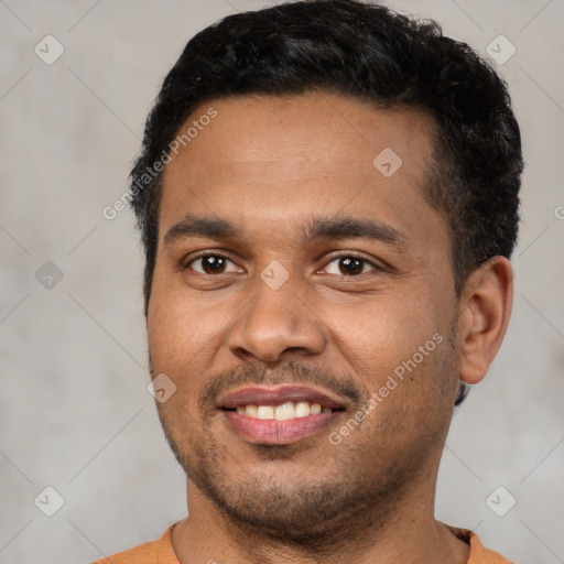 Joyful latino young-adult male with short  black hair and brown eyes