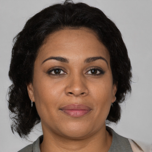 Joyful black adult female with medium  brown hair and brown eyes