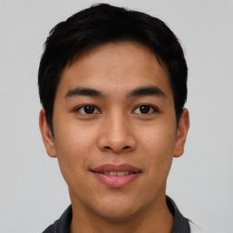 Joyful asian young-adult male with short  black hair and brown eyes