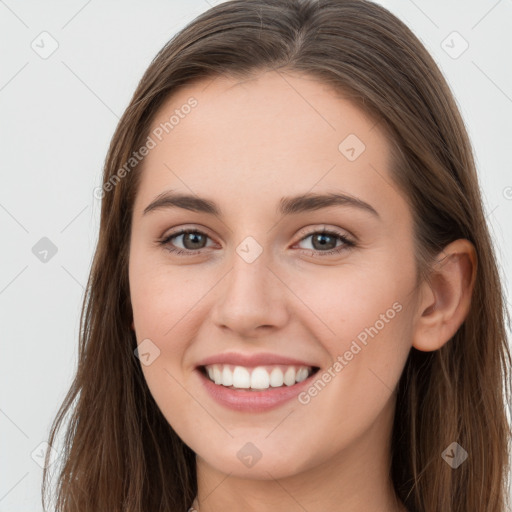 Joyful white young-adult female with long  brown hair and grey eyes