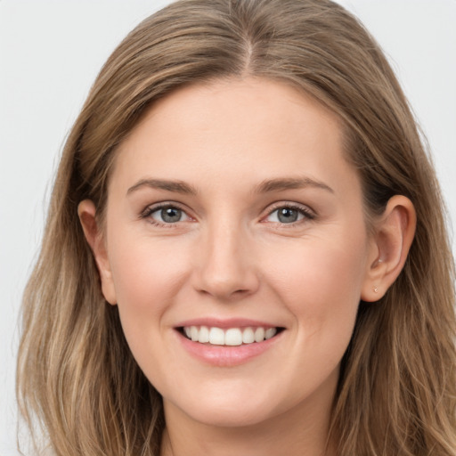 Joyful white young-adult female with long  brown hair and grey eyes