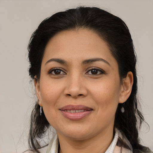 Joyful latino adult female with medium  brown hair and brown eyes