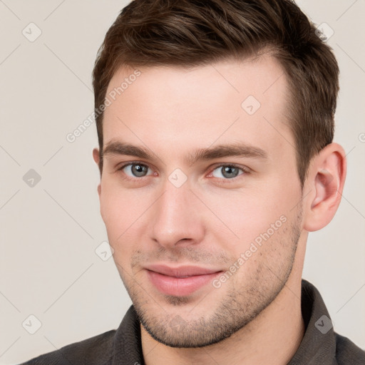 Joyful white young-adult male with short  brown hair and grey eyes