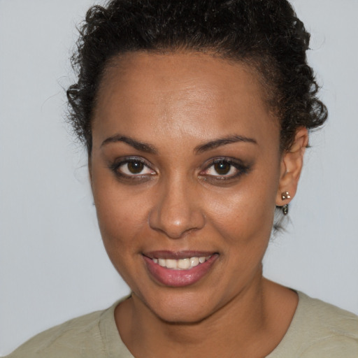 Joyful black young-adult female with short  brown hair and brown eyes