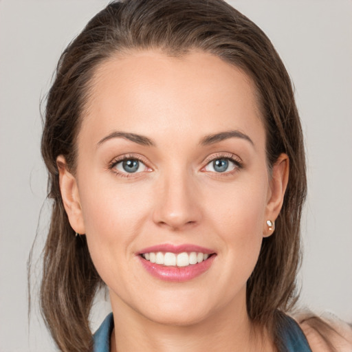 Joyful white young-adult female with medium  brown hair and grey eyes