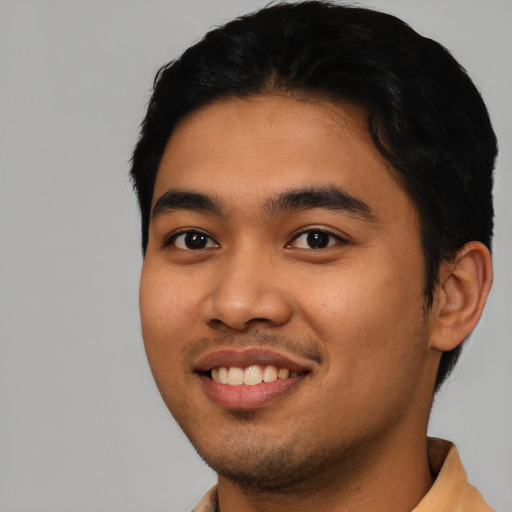 Joyful latino young-adult male with short  black hair and brown eyes