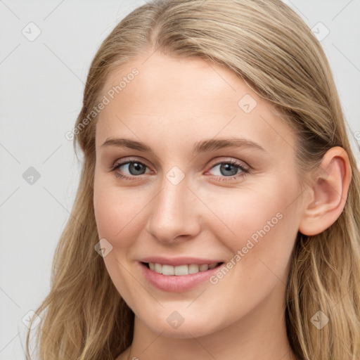 Joyful white young-adult female with long  brown hair and blue eyes