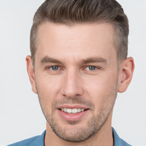 Joyful white young-adult male with short  brown hair and grey eyes