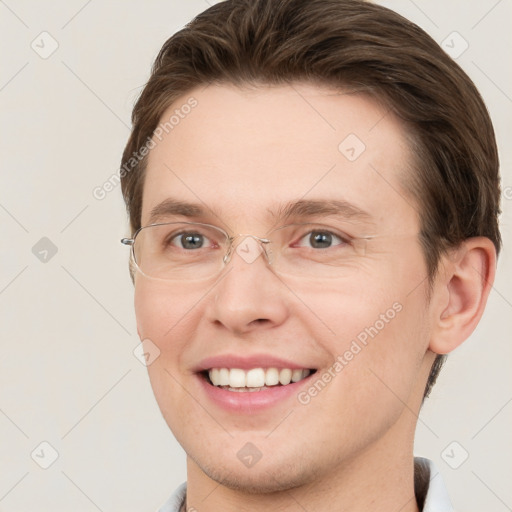 Joyful white young-adult male with short  brown hair and grey eyes