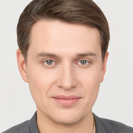 Joyful white young-adult male with short  brown hair and grey eyes