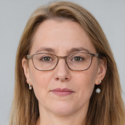 Joyful white adult female with long  brown hair and grey eyes