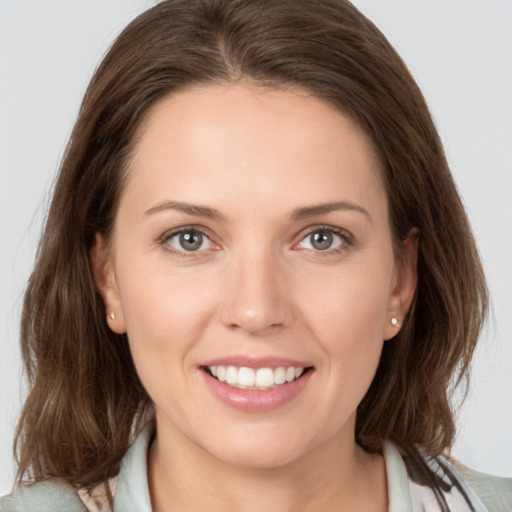 Joyful white young-adult female with medium  brown hair and grey eyes