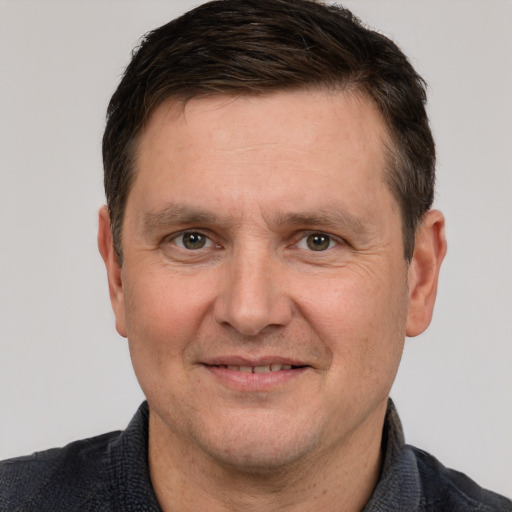 Joyful white adult male with short  brown hair and grey eyes