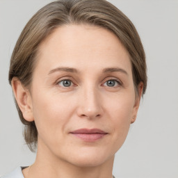 Joyful white adult female with medium  brown hair and grey eyes