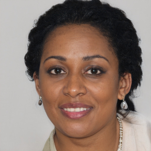 Joyful black adult female with short  black hair and brown eyes