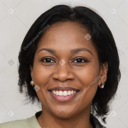 Joyful black adult female with medium  brown hair and brown eyes