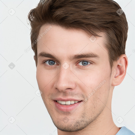 Joyful white young-adult male with short  brown hair and grey eyes