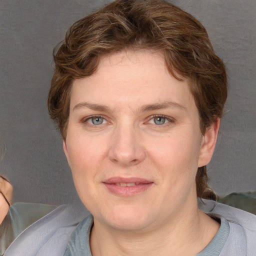 Joyful white adult female with short  brown hair and blue eyes