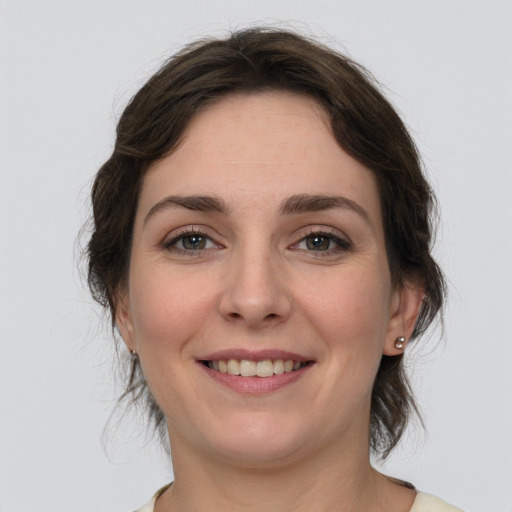 Joyful white young-adult female with medium  brown hair and green eyes