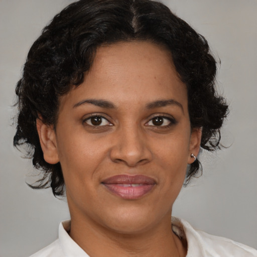 Joyful latino adult female with medium  brown hair and brown eyes
