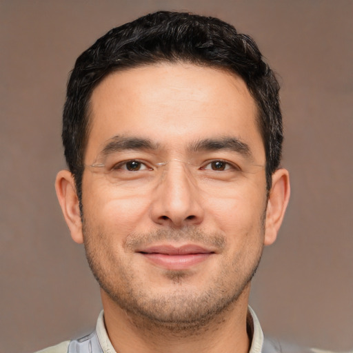 Joyful white young-adult male with short  black hair and brown eyes