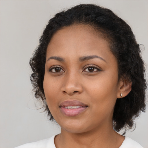 Joyful black young-adult female with medium  black hair and brown eyes