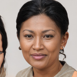 Joyful black adult female with medium  brown hair and brown eyes