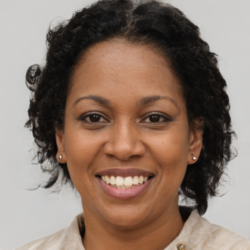 Joyful black adult female with medium  brown hair and brown eyes