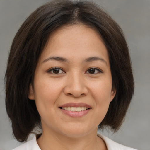 Joyful asian young-adult female with medium  brown hair and brown eyes