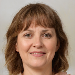 Joyful white adult female with medium  brown hair and grey eyes