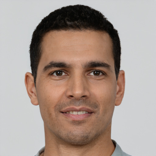 Joyful white young-adult male with short  black hair and brown eyes