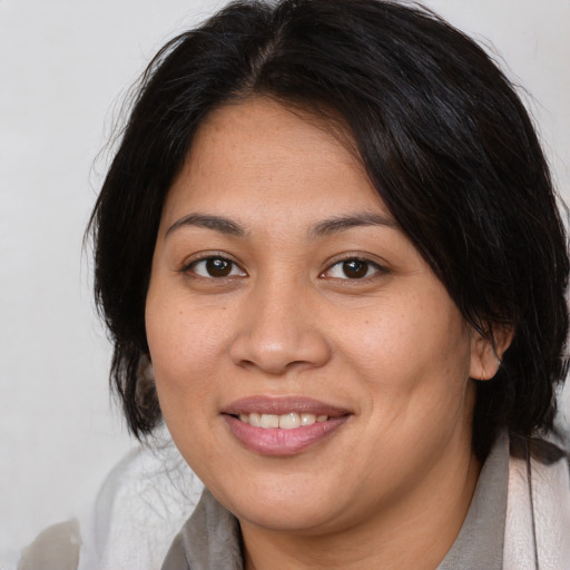 Joyful latino adult female with medium  brown hair and brown eyes