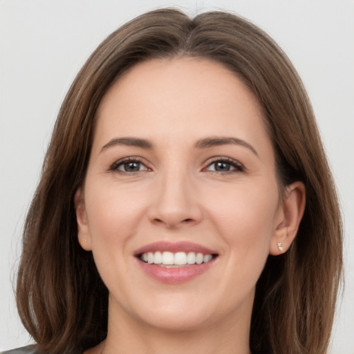 Joyful white young-adult female with long  brown hair and brown eyes