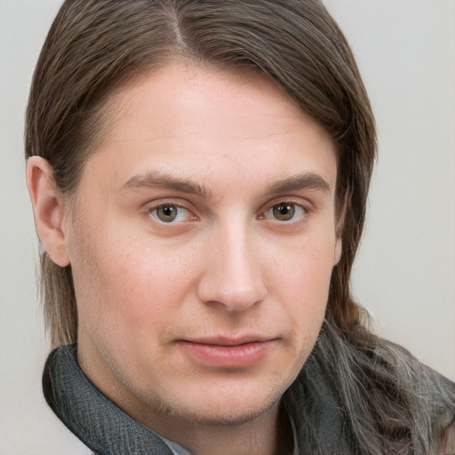 Joyful white young-adult male with long  brown hair and grey eyes