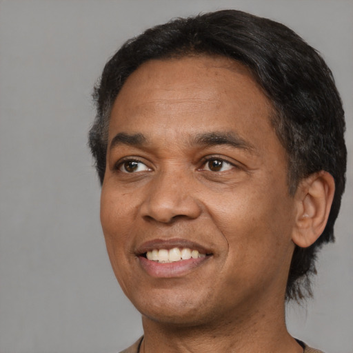 Joyful black adult male with short  black hair and brown eyes