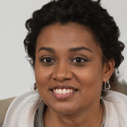 Joyful black young-adult female with long  brown hair and brown eyes