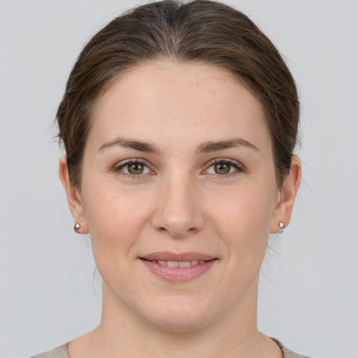 Joyful white young-adult female with short  brown hair and grey eyes