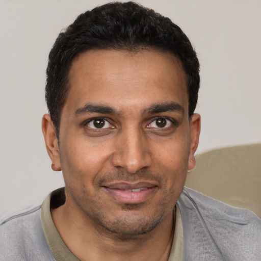 Joyful white young-adult male with short  black hair and brown eyes