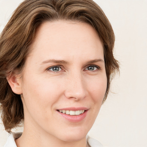 Joyful white young-adult female with medium  brown hair and green eyes