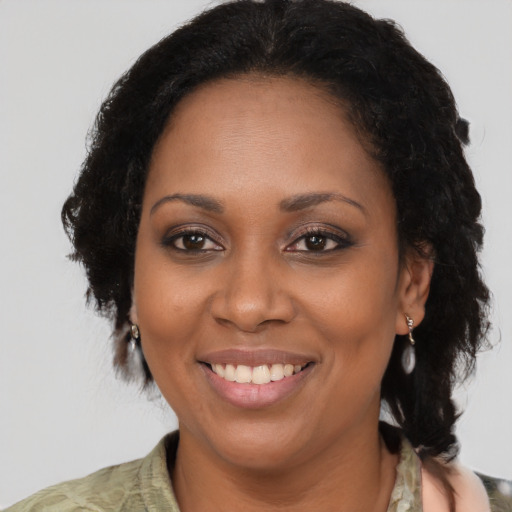 Joyful black adult female with medium  brown hair and brown eyes