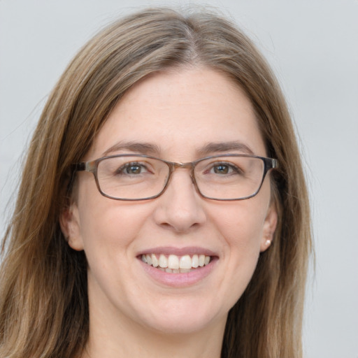 Joyful white adult female with long  brown hair and grey eyes